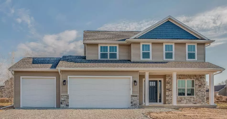 Newly constructed family home with a spacious front porch and modern design in a serene landscape