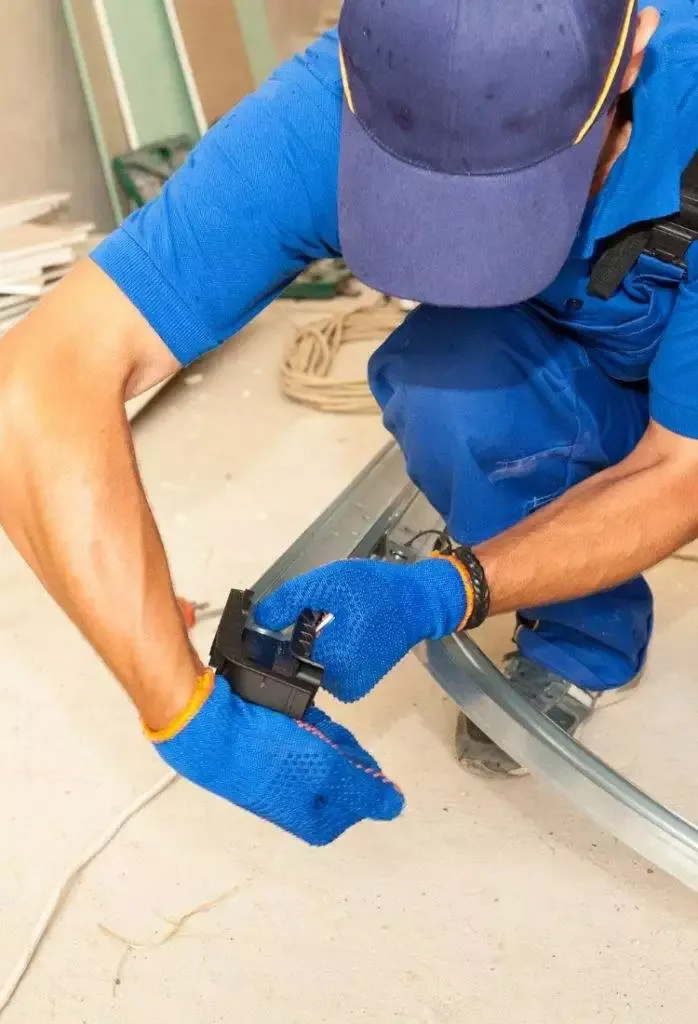 Construction worker performs assembly with tools in indoor renovation project using protective gloves Construction worker performs assembly with tools in indoor renovation project using protective gloves