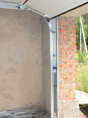 Garage door replacement project in progress at residential property with exposed interior walls Garage door replacement project in progress at residential property with exposed interior walls